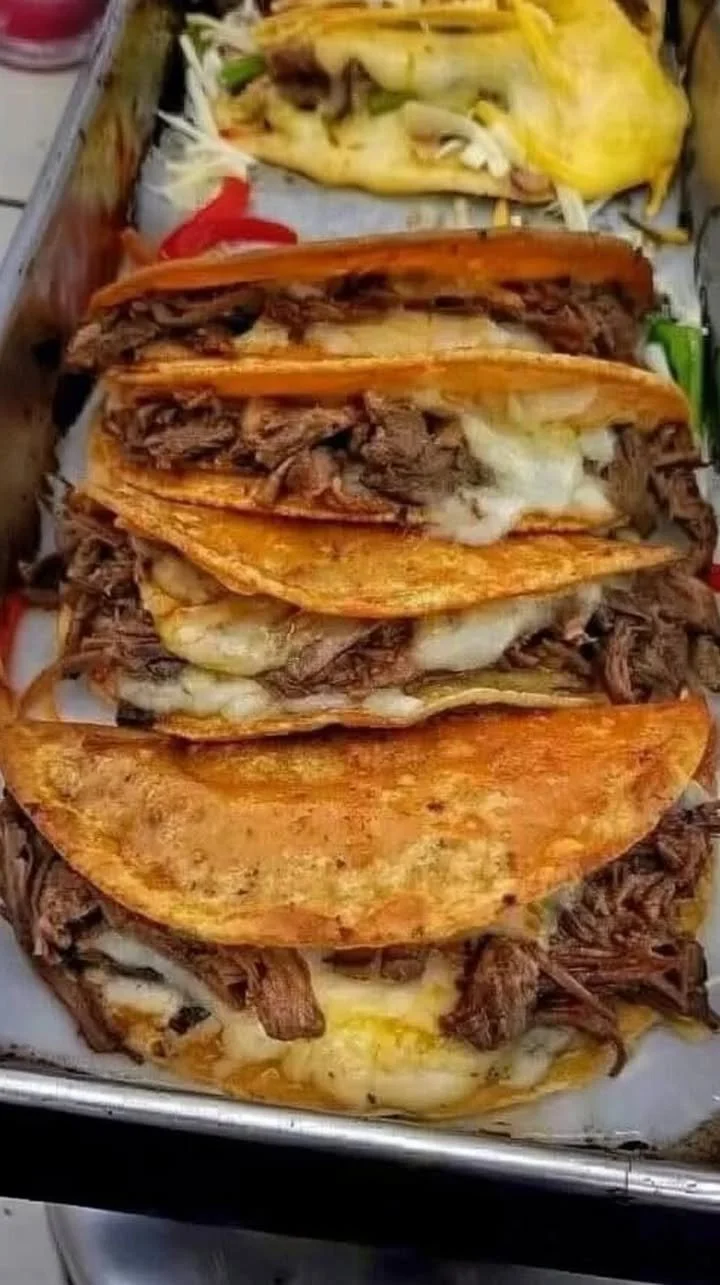 Delicious cheesy birria tacos with melted cheese and savory meat filling