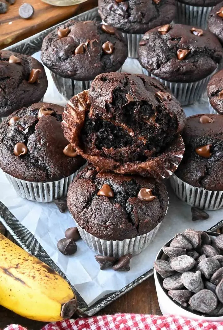 Double chocolate banana muffins fresh out of the oven, topped with chocolate chips.