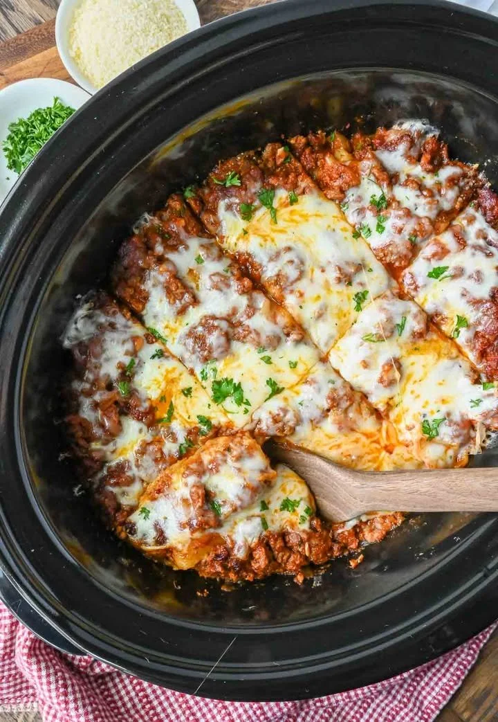 Delicious slow cooker lasagna topped with melted cheese and fresh herbs
