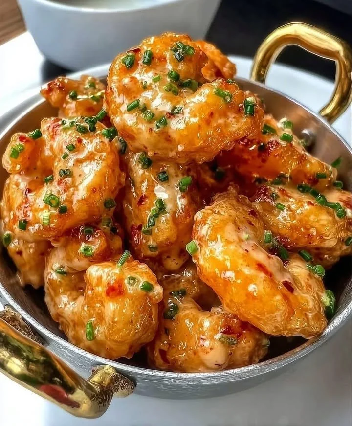 Plate of Spicy Bang Bang Shrimp garnished with green onions and sesame seeds
